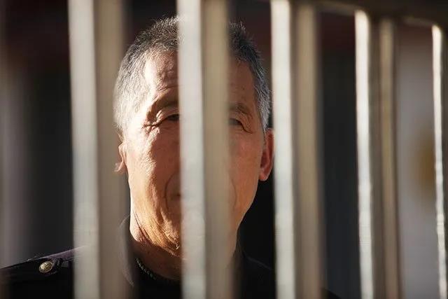 门卫正在隔着铁门望着医院之外亲人。